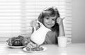 Milk for children. Fuuny little boy pouring whole milk for breakfast. Child boy eating organic healthy milk. Healthy