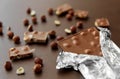 Milk chocolate bar with hazelnuts in foil wrapper Royalty Free Stock Photo