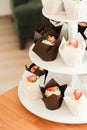 Milk and chocolate biscuit cupcakes with buttercream, decorated with fresh berries on a wooden stand