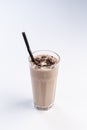 Milk-chocolate cocktail in a tall glass with a straw on white background Royalty Free Stock Photo