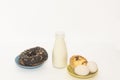 Milk, chocolate donuts, tart, eggs on white background