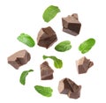 Milk chocolate pieces and mint falling on white background Royalty Free Stock Photo