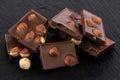 Milk chocolate pieces with nuts on a dark background Royalty Free Stock Photo