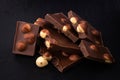 Milk chocolate pieces with nuts on a dark background Royalty Free Stock Photo