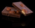 Milk chocolate pieces with nuts on a dark background Royalty Free Stock Photo