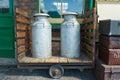 Milk churns on wooden trolley Royalty Free Stock Photo