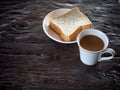 Milk coffee in white porcelain cup and whole wheat bread sheets Royalty Free Stock Photo