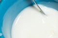 Milk in a cup with a metal spoon from above Royalty Free Stock Photo