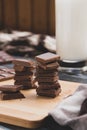 Milk dark chocolate tiles on wood cutting board, wooden background Royalty Free Stock Photo