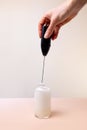 Milk foam maker with glass of milk on pink peach background Royalty Free Stock Photo