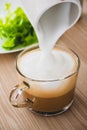 The milk foam is pouring into the coffee Royalty Free Stock Photo