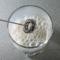 milk frother. frothed milk in a glass