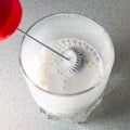 milk frother. frothed milk in a glass