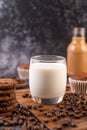 Milk in a glass, complete with coffee beans, cupcakes, bananas and cookies on a wooden plate