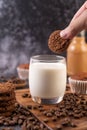 Milk in a glass, complete with coffee beans, cupcakes, bananas and cookies on a wooden plate