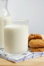 Milk in glass containers and almond raisins cookies placed on napkin, breakfast concept.