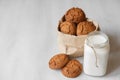 Milk in a glass jar and oatmeal cookies in a paper bag on a white table background. Copy, empty space for text Royalty Free Stock Photo