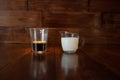 Milk in glass milk jug with a cup of coffee in a transparent glass