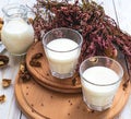 Milk, heather flowers and walnuts. Wooden table.