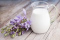 Milk jug and bluebell flowers bunch on wooden rustic board Royalty Free Stock Photo