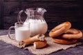 Milk in a jug and cups and bagels on a table