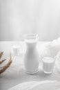 Milk in a jug and glasses on a white background. Tablecloth. Flowers . copy space Royalty Free Stock Photo