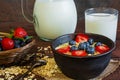 Milk in a jug and oatmeal porridge with glass of milk in a pottery bowl with fresh ripe berrie Royalty Free Stock Photo