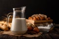 Milk in a jug placed on a wooden table with ingredients