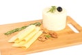 Milk nutritious product cheese portioned and piece on a wooden board with rosemary and olives.