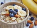 Milk oatmeal with bananas, almonds, blueberries and chia seeds. Healthy, vegetarian breakfast