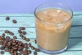 milk pour in glass of iced coffee on blue background