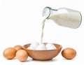 Milk Pouring Into Bowl of Eggs with Brown Shells Isolated on White Background Royalty Free Stock Photo