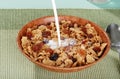 Milk pouring into bran and raisin cereal Royalty Free Stock Photo