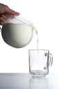 Milk pouring into empty glass cup Royalty Free Stock Photo