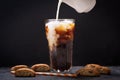 Milk pouring into glass of iced coffee Royalty Free Stock Photo