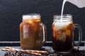 Milk pouring into jar of iced coffee Royalty Free Stock Photo