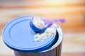 Milk powder in spoon on can for baby and wooden table Royalty Free Stock Photo