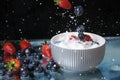 Milk splash close up of falling berries in a grey plate of milk. Blueberries and Strawberries multivitamin cocktail. Healthy diet. Royalty Free Stock Photo