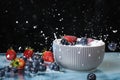 Milk splash close up of falling berries in a grey plate of milk. Blueberries and Strawberries multivitamin cocktail. Healthy diet. Royalty Free Stock Photo