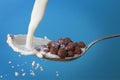 Milk splashing into spoon with cornballs Royalty Free Stock Photo