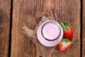 Milk (Strawberry flavoured) on wooden background