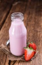 Milk (Strawberry flavoured) on wooden background