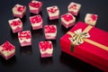 Milk and white belgian chocolates with red gift box with gold ribbon tied into bow. Royalty Free Stock Photo