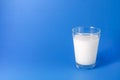Milk in a young glass on a blue background