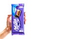 Milka Alpine Milk Chocolate. Studio shot, woman holding a Milka chocolate isolated on white background in Bucharest, Romania, 2019 Royalty Free Stock Photo