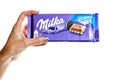 Milka Alpine Milk Chocolate. Studio shot, woman holding a Milka chocolate isolated on white background in Bucharest, Romania, 2019 Royalty Free Stock Photo