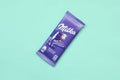 Milka chocolate tablet in classic violet wrapping on pastel blue background. Milka is brand of chocolate confection originated in Royalty Free Stock Photo