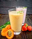 Milkshake apricot and strawberry in glassfulls on board Royalty Free Stock Photo