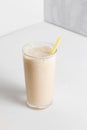 Milkshake with banana in high transparent glass on a white background. A healthy drink for a diet Royalty Free Stock Photo