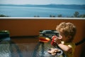 Milkshake and cookies for baby breakfast. Child eating breakfast on the terrace by the sea.